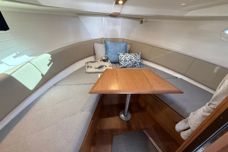 Slide: The Image of 2026 Cutwater C-288 CB cabin interior with cozy seating and wooden table. - 16