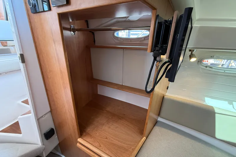 Slide: The Image of 2026 Cutwater C-288 CB interior with wooden storage and mounted TV. - 18