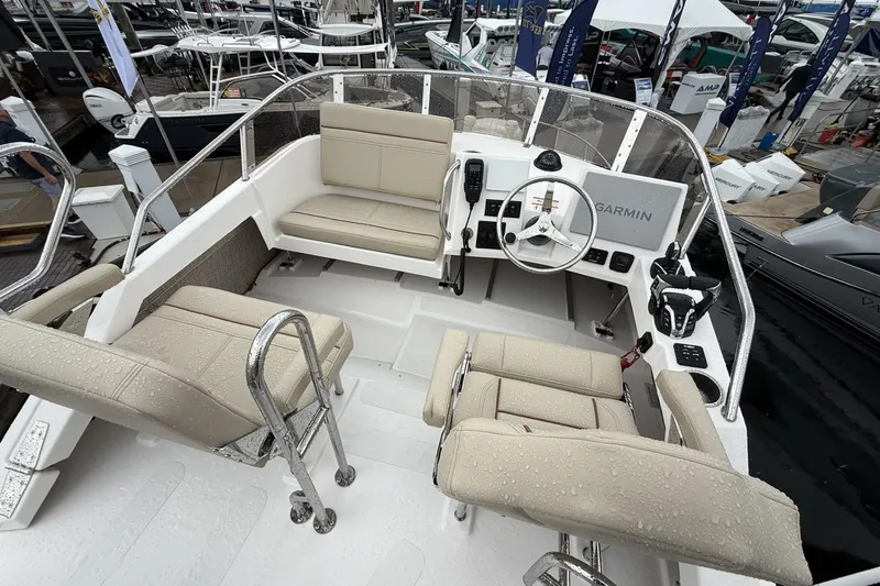 Slide: The Image of 2026 Cutwater C-288 CB boat interior with beige seating and Garmin navigation system. - 2