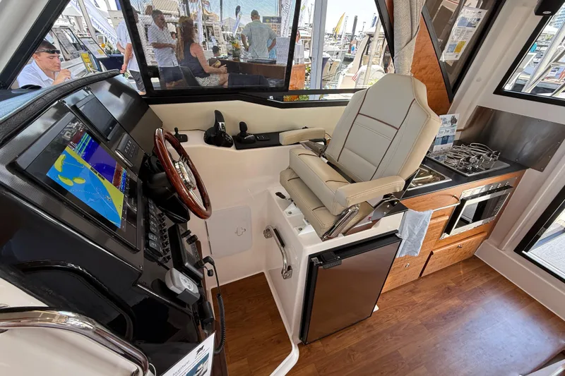 Slide: The Image of 2026 Cutwater C-288 CB boat interior with helm, navigation screen, and compact kitchen. - 21