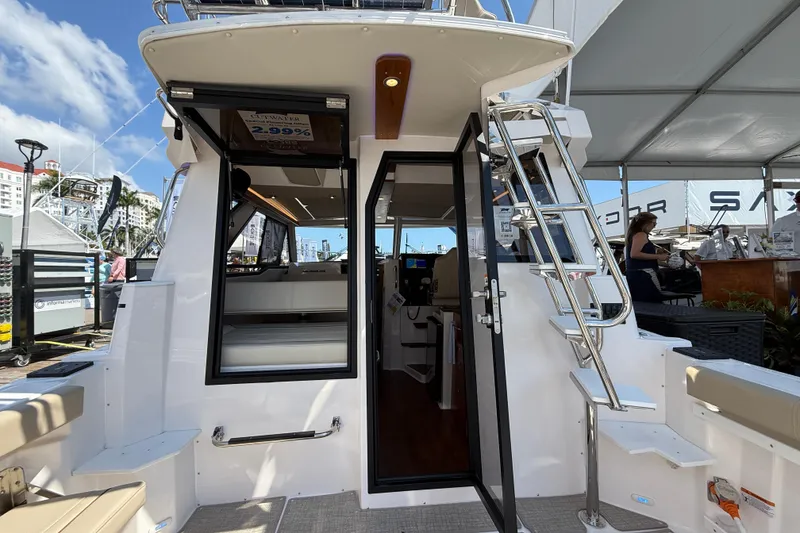 Slide: The Image of 2026 Cutwater C-288 CB boat with open cabin door and ladder, docked at marina. - 9
