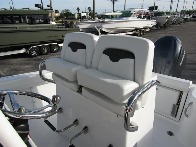 Slide: The Image of 2025 Wellcraft 243 Fisherman boat interior with dual white seats and steering wheel. - 16