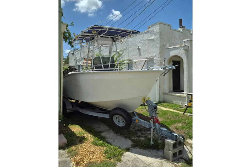 Slide: The Image of 1993 Cape Horn 22 OS boat with center console and canopy, parked outdoors. - 2