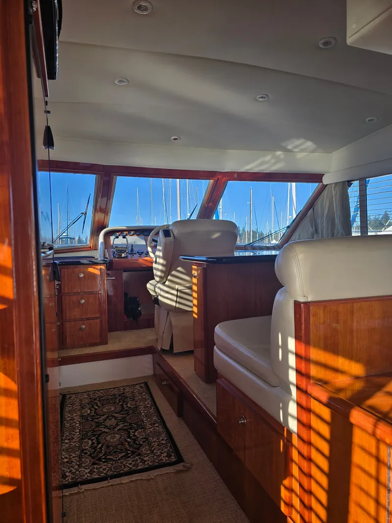 Slide: The Image of Interior of a 2005 Navigator 44C yacht with wooden furnishings and cushioned seating. - 18