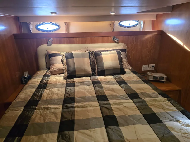 Slide: The Image of Bedroom in Navigator 44C yacht, 2005 model, featuring plaid bedding. - 30