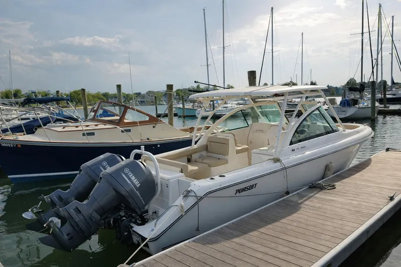 Slide: The Image of 2015 Pursuit DC 265 Dual Console boat docked at marina with Yamaha engines. - 1