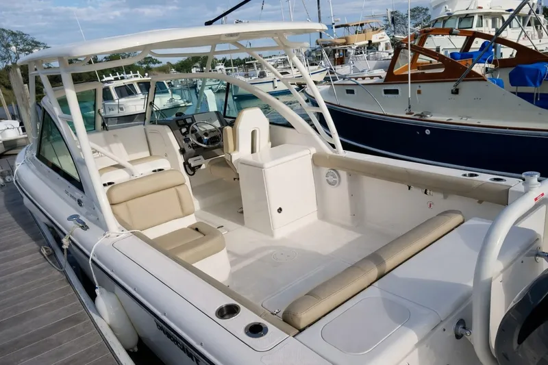 Slide: The Image of 2015 Pursuit DC 265 Dual Console boat docked, featuring spacious seating and modern design. - 3