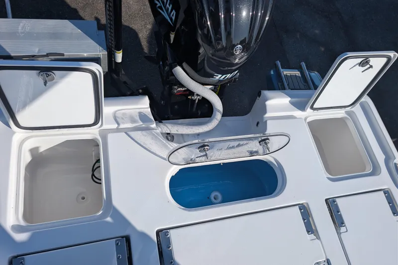 Slide: The Image of 2026 Tidewater 2500 Carolina Bay boat with open storage compartments and Yamaha engine. - 14