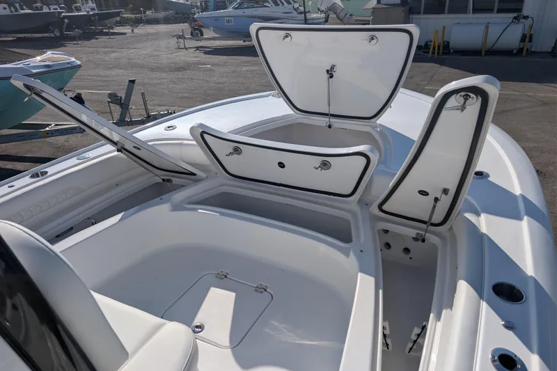 Slide: The Image of 2026 Tidewater 2500 Carolina Bay boat with open storage compartments on deck. - 2