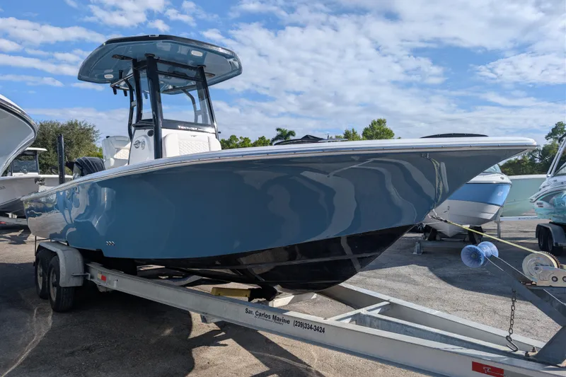 Slide: The Image of 2026 Tidewater 2500 Carolina Bay boat on trailer under blue sky. - 23