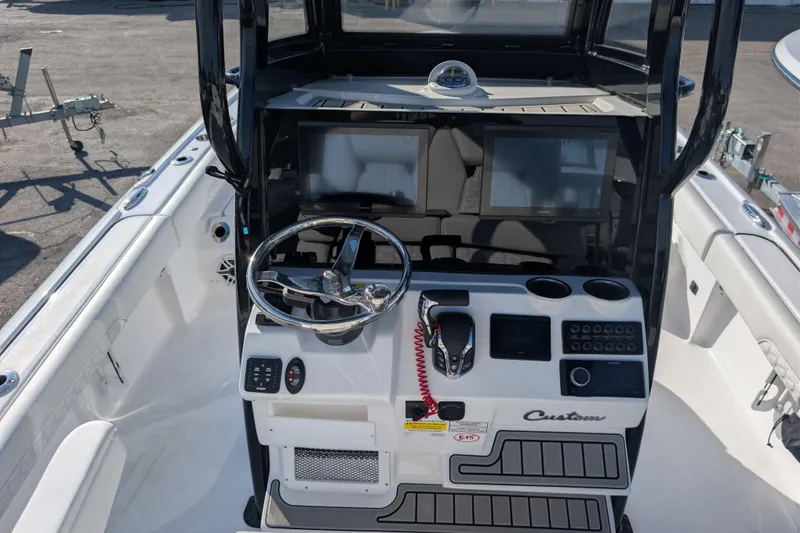 Slide: The Image of 2026 Tidewater 2500 Carolina Bay boat console with steering wheel and navigation screens. - 7