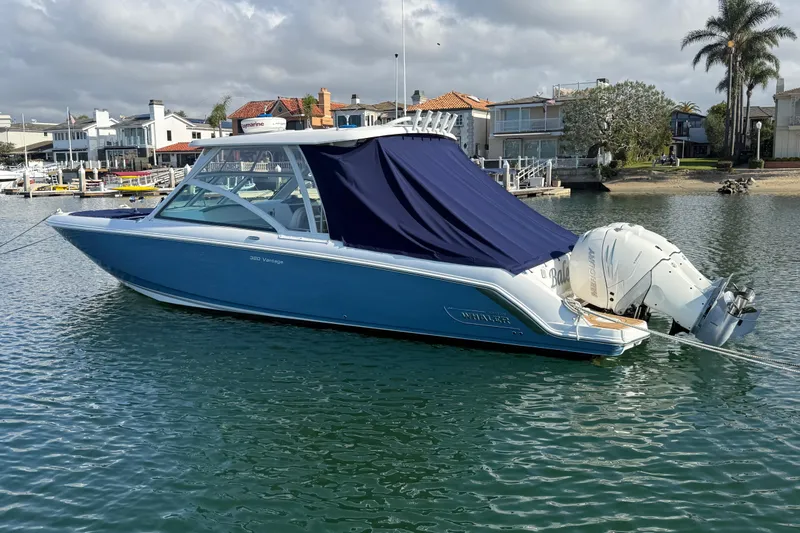 Slide: The Image of 2020 Boston Whaler 320 Vantage boat docked in a scenic waterfront setting. - 10