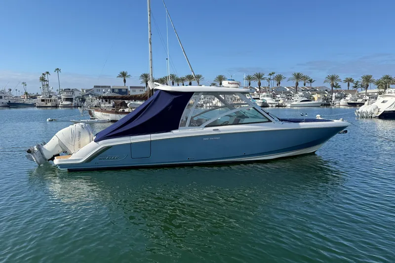 Slide: The Image of 2020 Boston Whaler 320 Vantage boat docked in a marina with palm trees. - 11