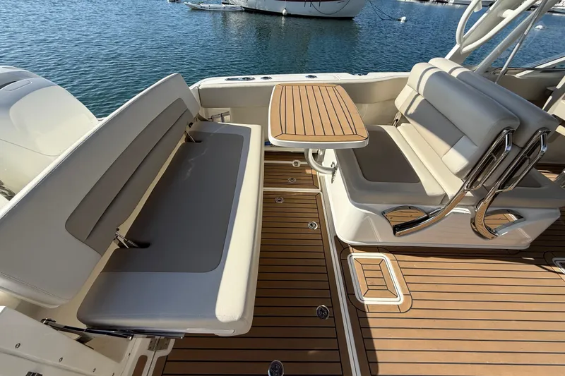 Slide: The Image of 2020 Boston Whaler 320 Vantage boat interior with seating and table on teak deck. - 21