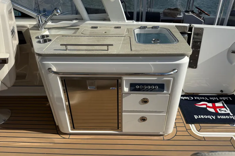 Slide: The Image of 2020 Boston Whaler 320 Vantage boat interior with beige seating and wooden deck. - 23