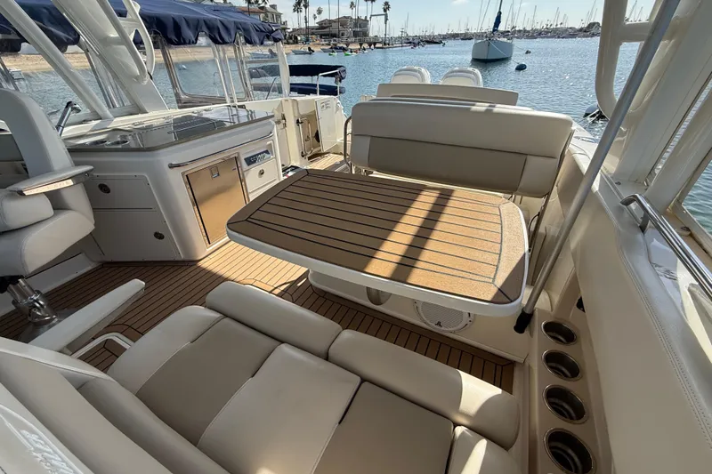 Slide: The Image of 2020 Boston Whaler 320 Vantage interior with seating and table, docked at marina. - 28