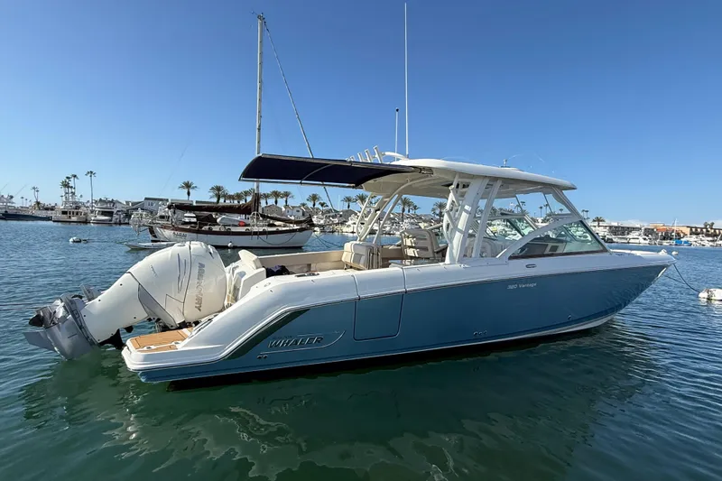 Slide: The Image of 2020 Boston Whaler 320 Vantage boat docked in a marina under clear blue skies. - 3