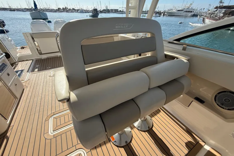 Slide: The Image of 2020 Boston Whaler 320 Vantage boat interior with seating, docked in a marina. - 33