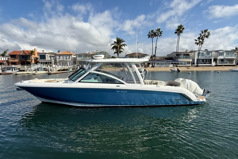 Slide: The Image of 2020 Boston Whaler 320 Vantage boat on calm water near waterfront homes. - 4