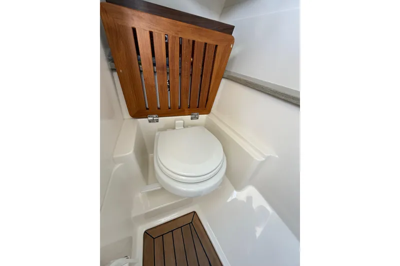 Slide: The Image of 2020 Boston Whaler 320 Vantage boat interior with wooden toilet seat and flooring. - 46