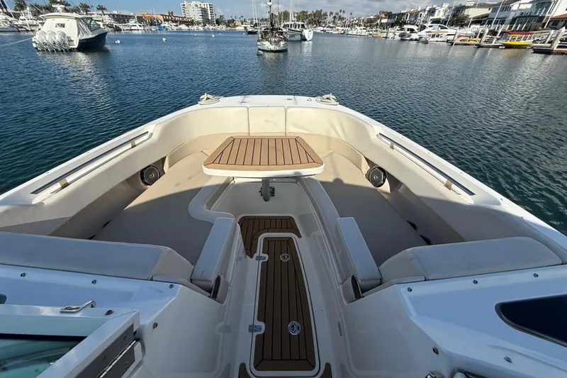 Slide: The Image of 2020 Boston Whaler 320 Vantage boat interior with seating and table, docked in marina. - 49