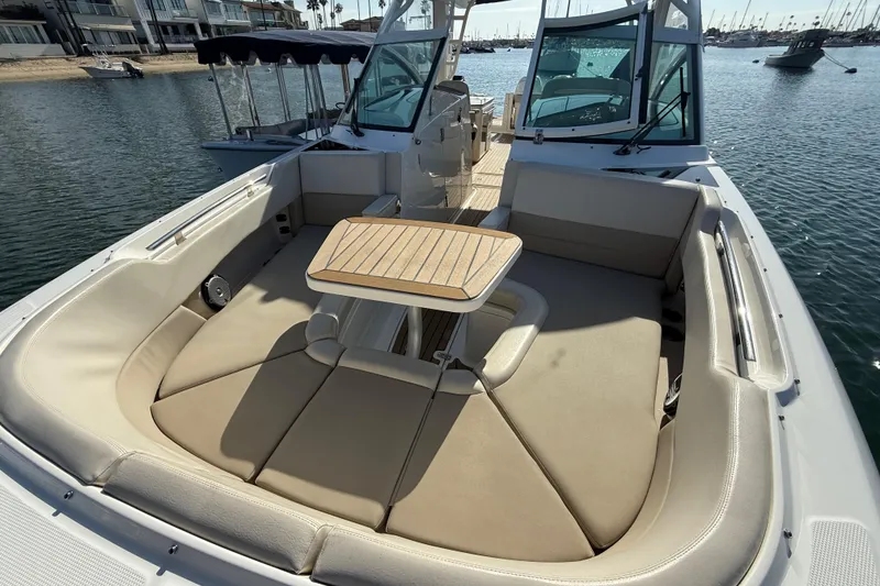 Slide: The Image of 2020 Boston Whaler 320 Vantage boat with spacious seating and table on calm water. - 50