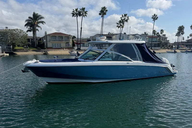 Slide: The Image of 2020 Boston Whaler 320 Vantage boat docked in a scenic waterfront setting. - 8