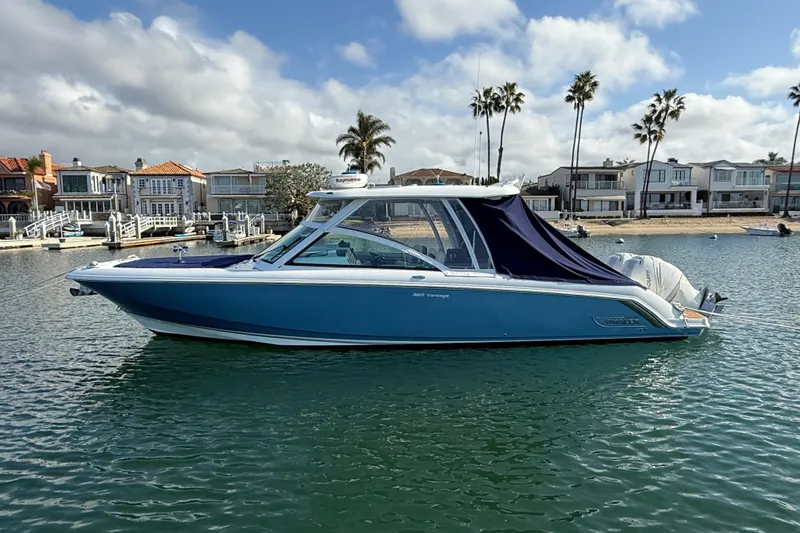Slide: The Image of 2020 Boston Whaler 320 Vantage boat docked in a scenic waterfront setting. - 9