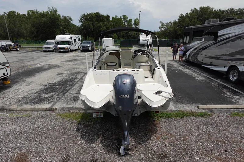 Slide: The Image of 2022 Stingray 231 DC boat parked in a lot with RVs and cars. - 13