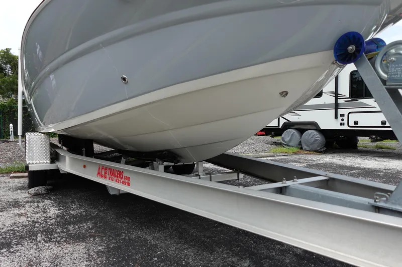 Slide: The Image of 2022 Stingray 231 DC boat on trailer, parked near RV. - 14