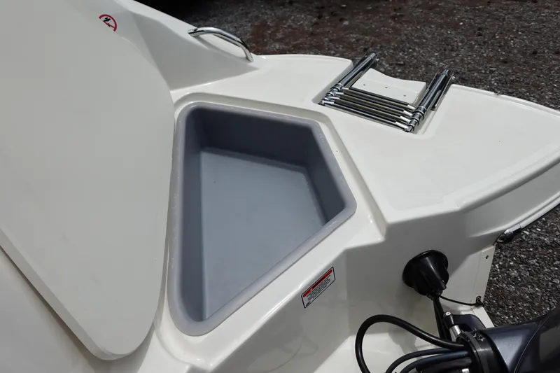 Slide: The Image of 2022 Stingray 231 DC boat with storage compartment and ladder on deck. - 21