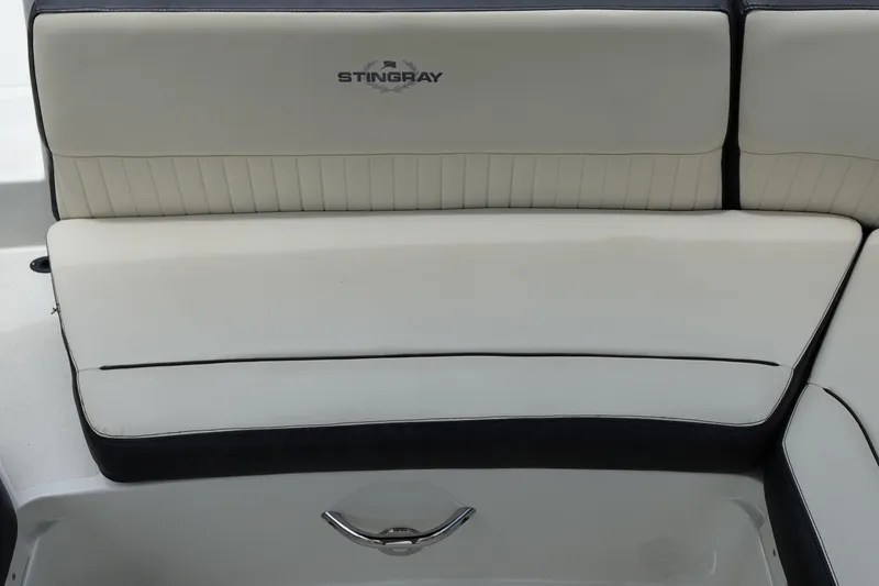 Slide: The Image of 2022 Stingray 231 DC boat seat with logo, featuring sleek white and black upholstery. - 28