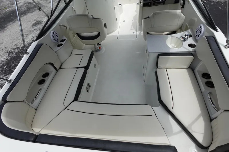 Slide: The Image of 2022 Stingray 231 DC boat interior with white seating and cup holders. - 3