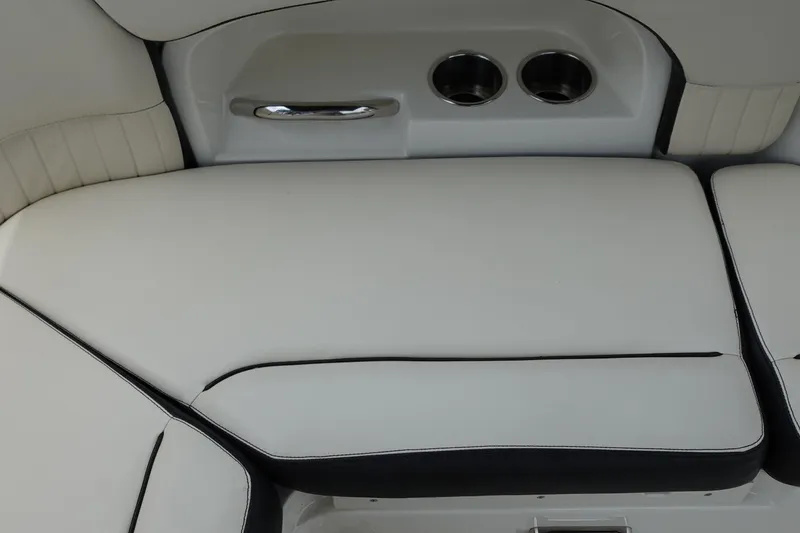 Slide: The Image of 2022 Stingray 231 DC boat interior with white cushioned seating and cup holders. - 31