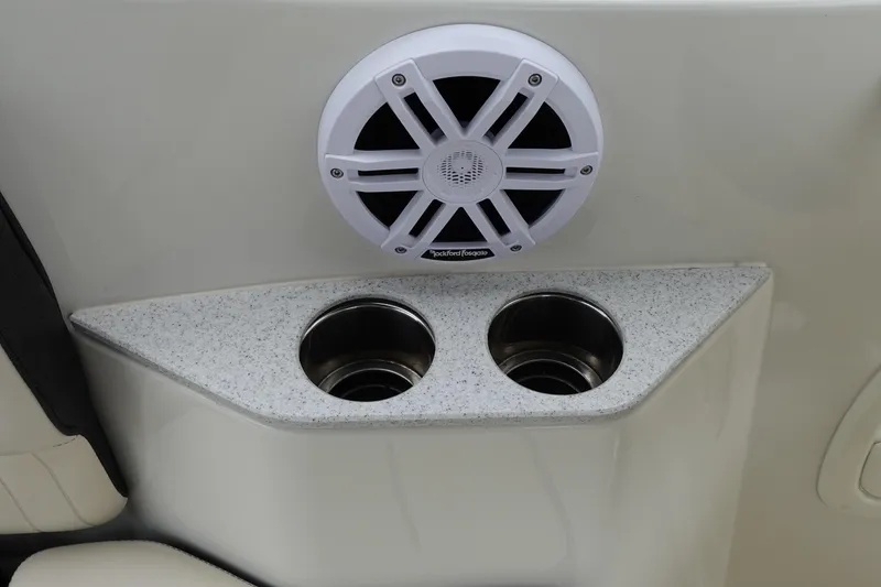 Slide: The Image of 2022 Stingray 231 DC boat interior with speaker and dual cup holders. - 34