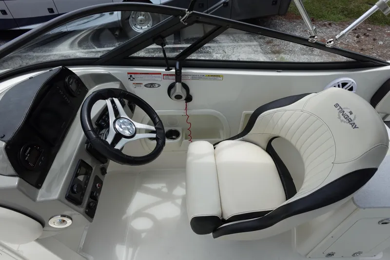 Slide: The Image of 2022 Stingray 231 DC boat interior with steering wheel and branded seat. - 39