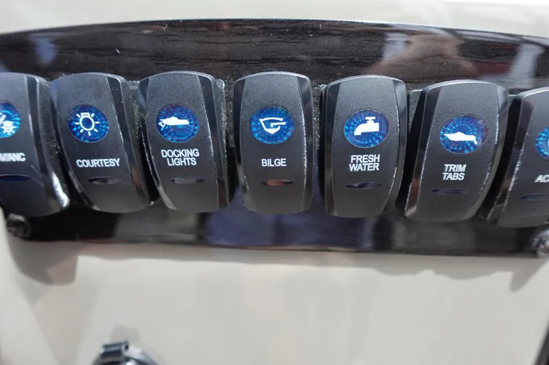 Slide: The Image of Control panel switches on a 2022 Stingray 231 DC boat. - 43