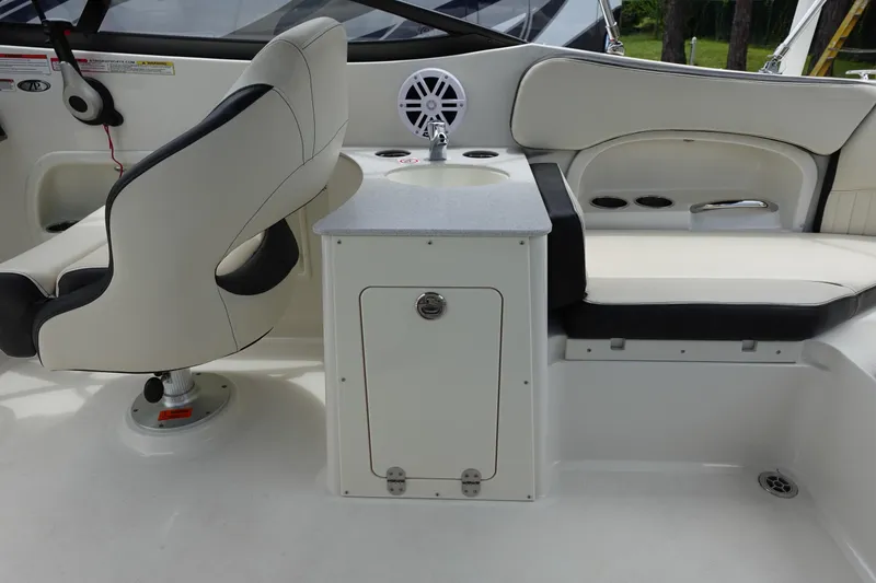 Slide: The Image of 2022 Stingray 231 DC boat interior with seating, sink, and storage cabinet. - 6
