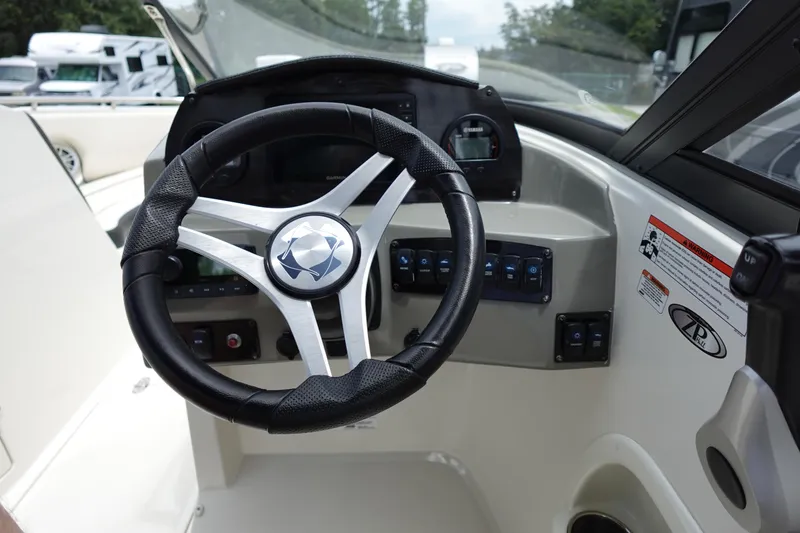 Slide: The Image of 2022 Stingray 231 DC boat dashboard with steering wheel and control panel. - 8