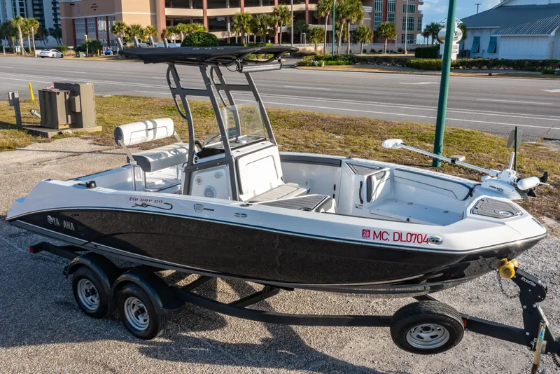 The Image of 2019 Yamaha Boats 210 FSH Sport on trailer, parked near a road. - 0