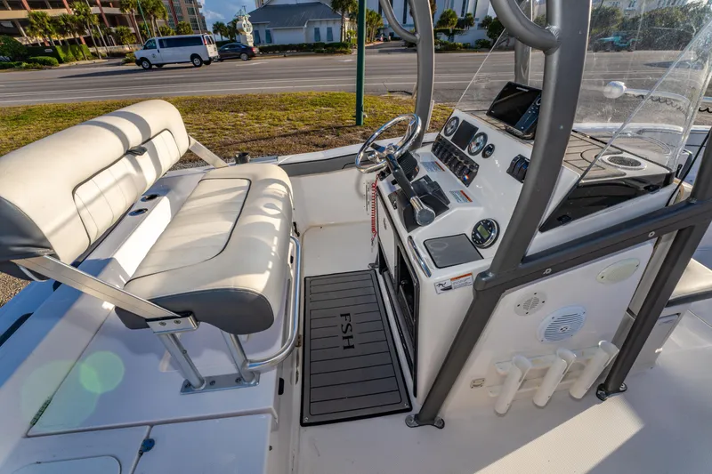 Slide: The Image of 2019 Yamaha Boats 210 FSH Sport interior with helm, seating, and controls. - 17