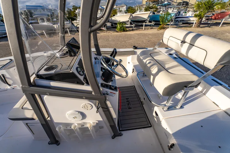 Slide: The Image of 2019 Yamaha Boats 210 FSH Sport interior with steering console and seating. - 18