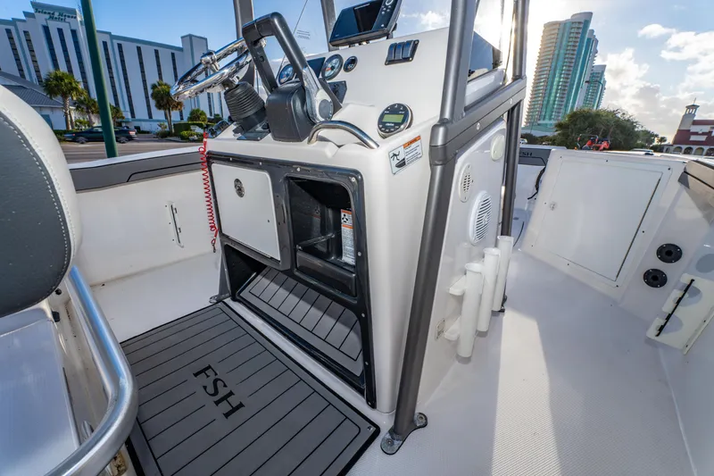 Slide: The Image of 2019 Yamaha Boats 210 FSH Sport interior with steering console and storage compartments. - 22