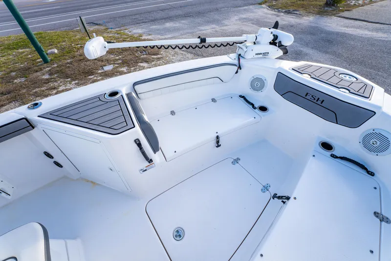 Slide: The Image of 2019 Yamaha Boats 210 FSH Sport interior with seating, storage, and Minn Kota trolling motor. - 27