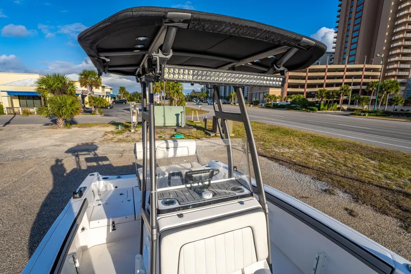 Slide: The Image of 2019 Yamaha Boats 210 FSH Sport with T-top, parked near a coastal road. - 31
