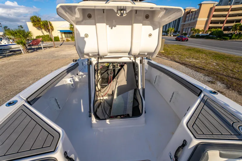 Slide: The Image of 2019 Yamaha Boats 210 FSH Sport open storage compartment, showcasing interior wiring and components. - 33