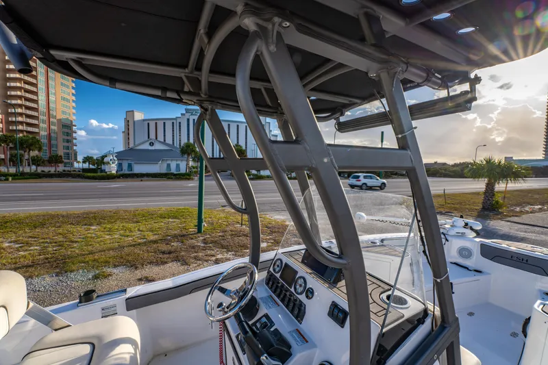 Slide: The Image of 2019 Yamaha Boats 210 FSH Sport interior with steering wheel, dashboard, and urban backdrop. - 34