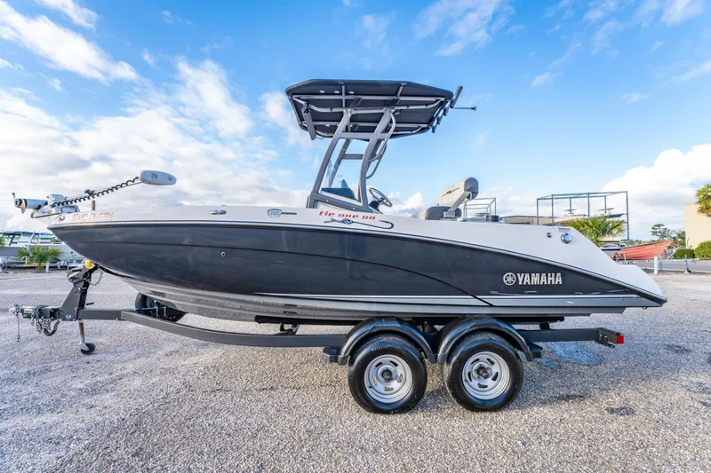 Slide: The Image of 2019 Yamaha Boats 210 FSH Sport on trailer under blue sky. - 9