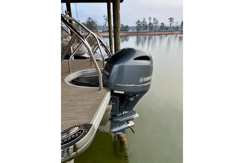 Slide: The Image of 2019 Godfrey Sweetwater boat with Yamaha outboard motor on a calm lake. - 10