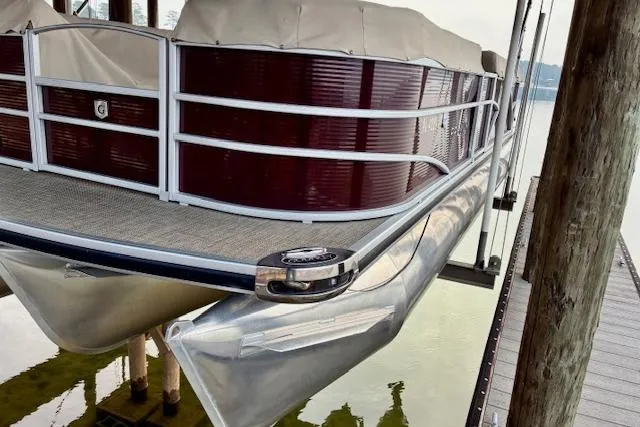 Slide: The Image of 2019 Godfrey Sweetwater pontoon boat docked, featuring maroon panels and aluminum pontoons. - 11